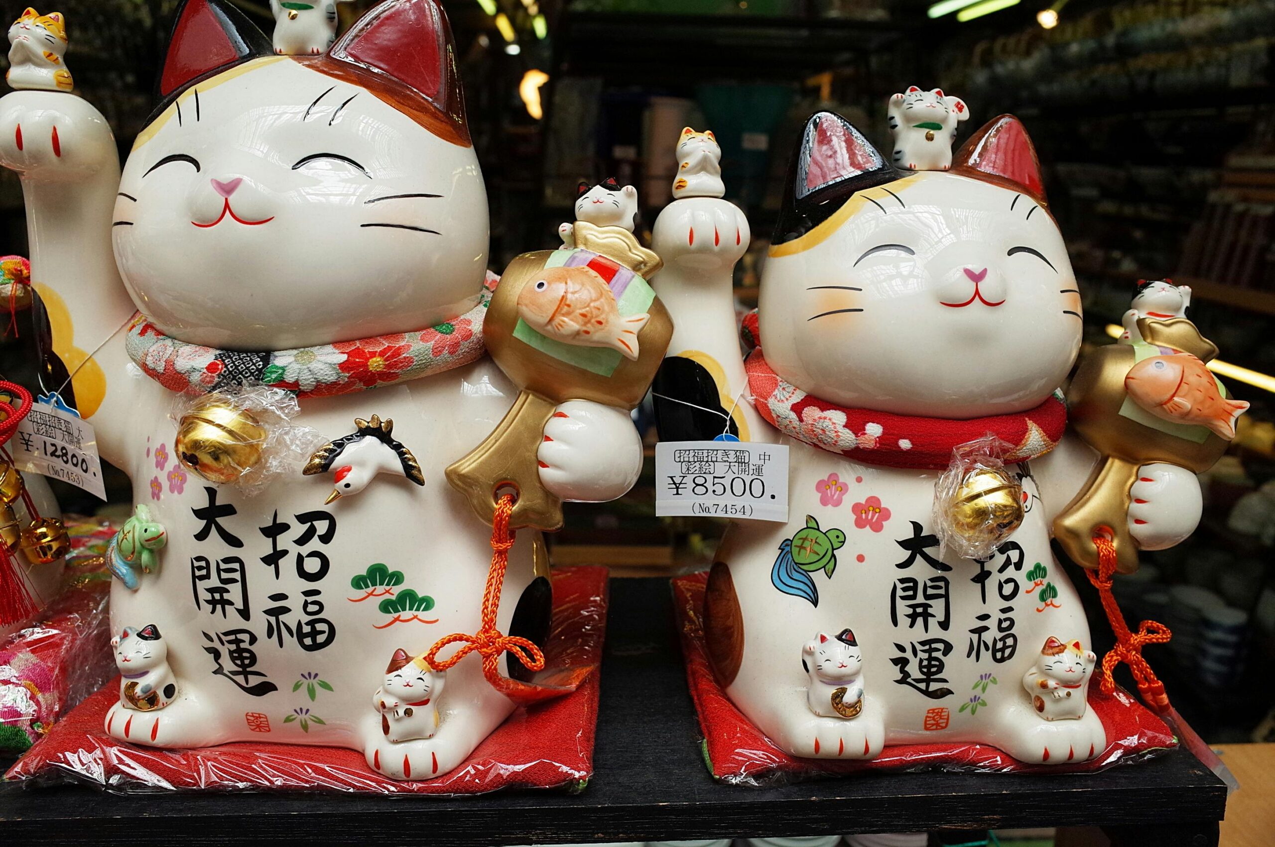 Colorful ceramic Maneki Neko figurines displayed in a Nagoya shop, symbolizing luck and prosperity.
