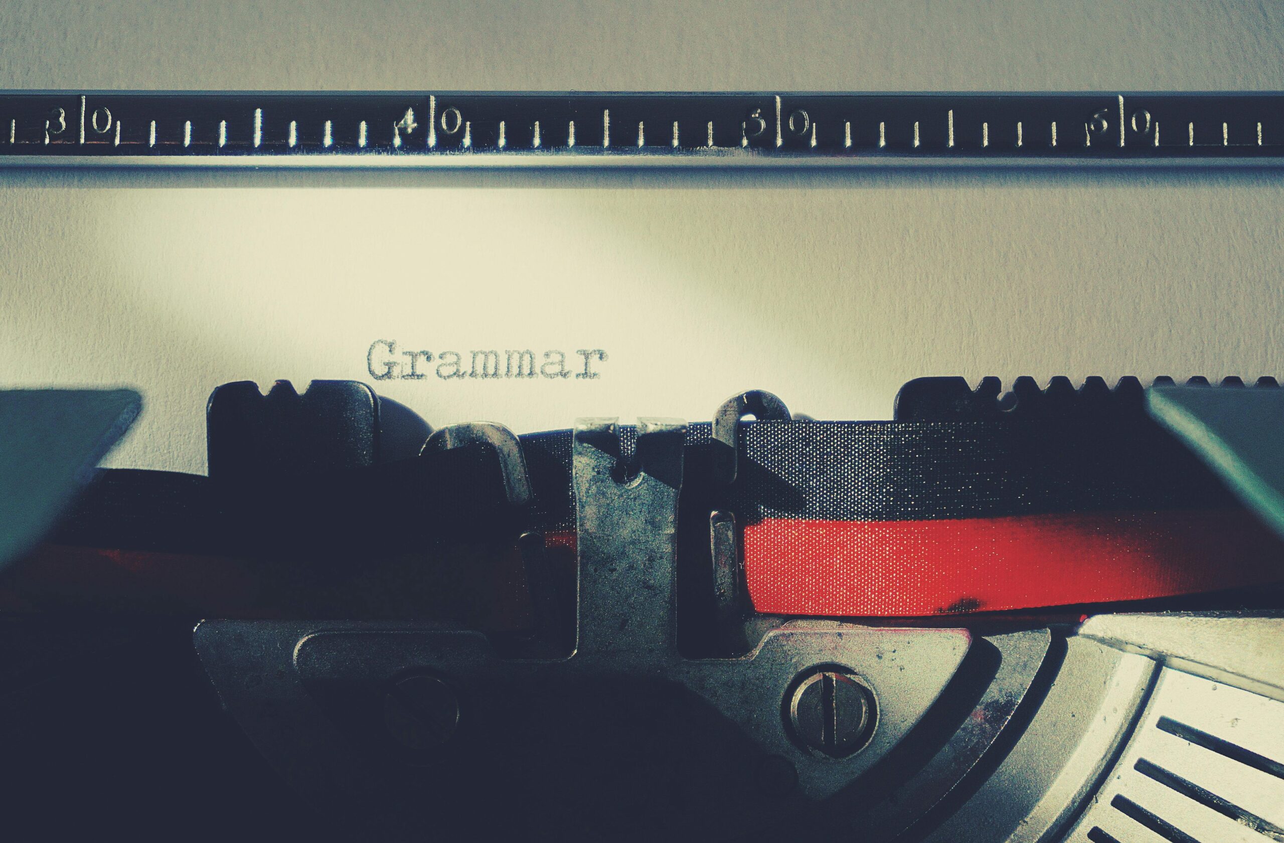 A detailed close-up of a vintage typewriter typing the word 'Grammar'.